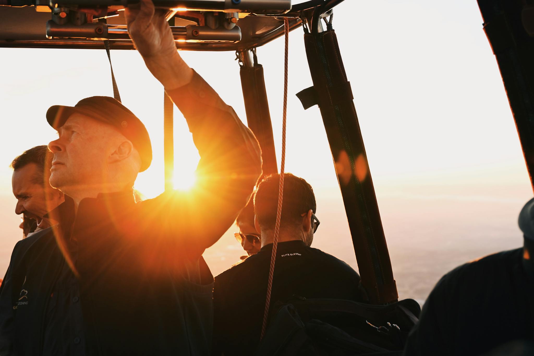 A vibrant sunrise view from a hot air balloon with passengers on board.